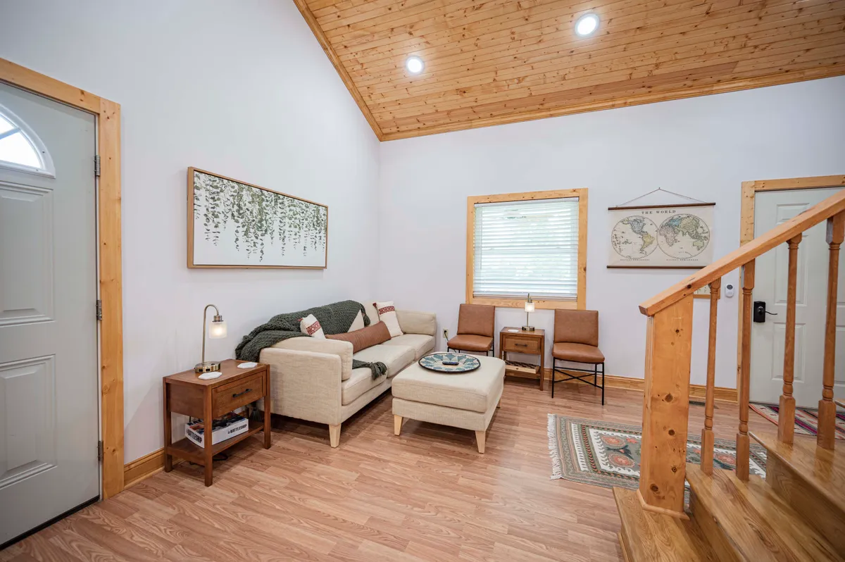 A cozy living room with a comfortable sofa, a coffee table, and tasteful wall art. The area is well-lit and welcoming, perfect for unwinding after work, casual meetings, or focused solo sessions.